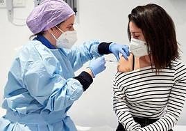 Una enfermera aplica la vacuna a una profesora.