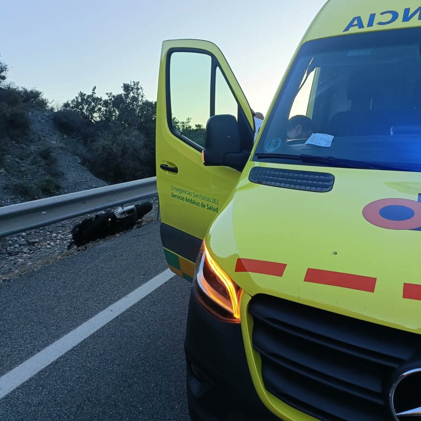 Una ambulancia del 061 junto a la motocicleta accidentada.