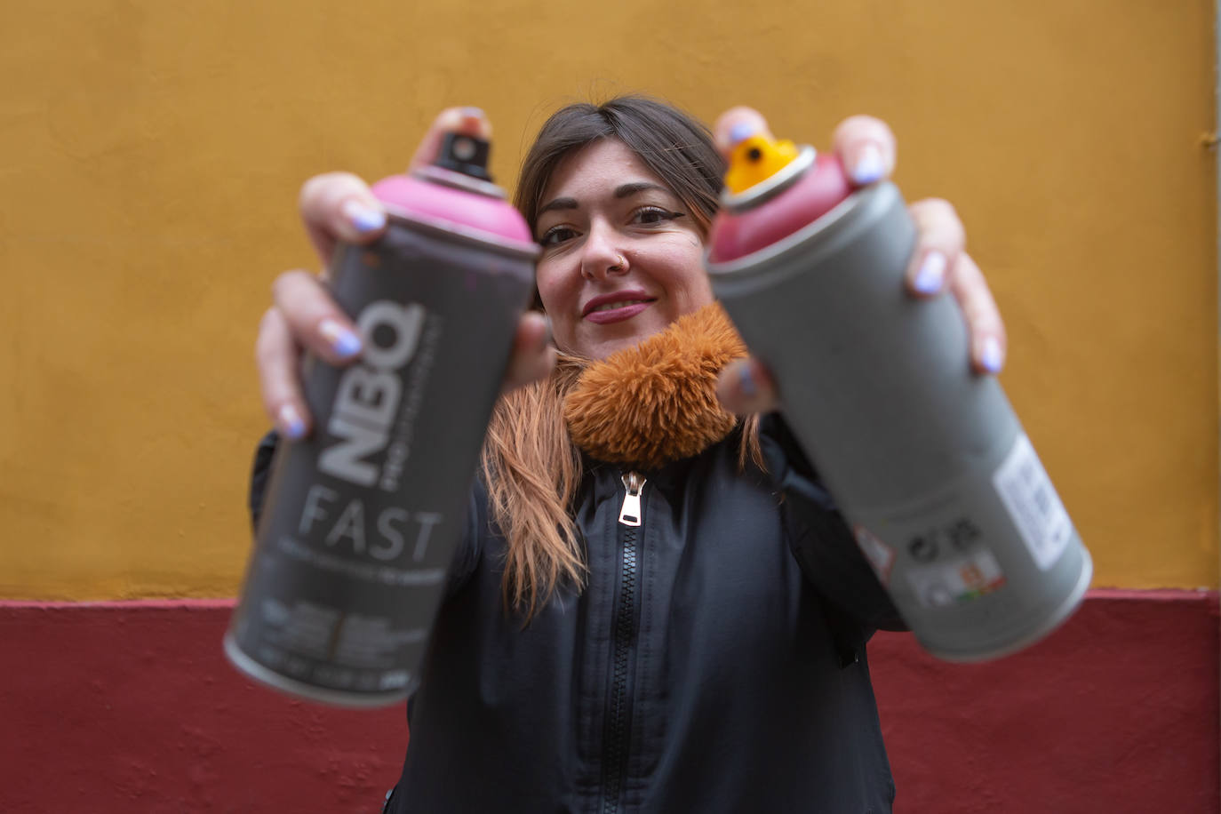 La artista urbana MaríaDie, con los botes de espray con los que ejecuta sus creaciones.