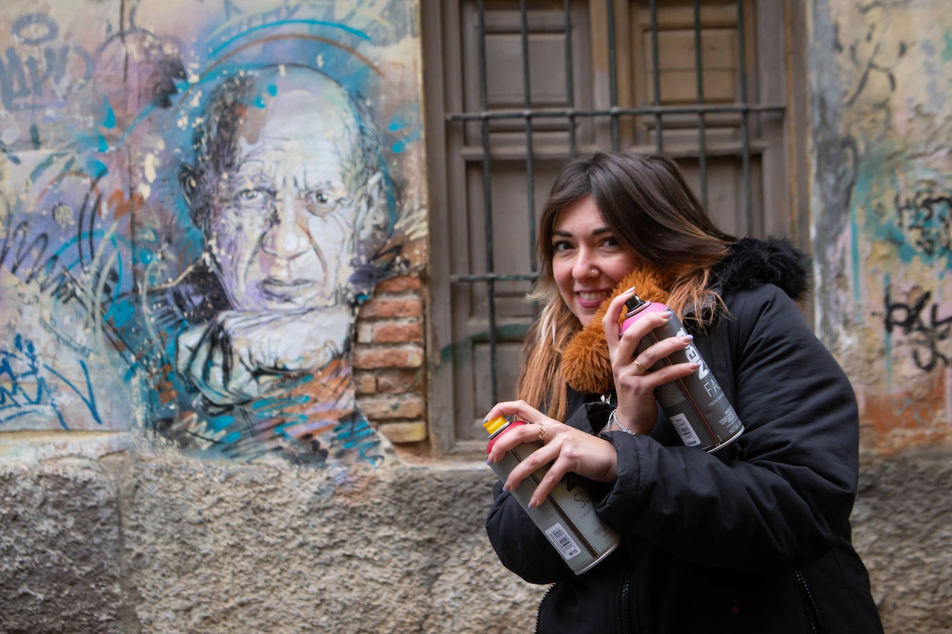 MaríaDie junto a uno de los grafitis del barrio de la Magdalena.