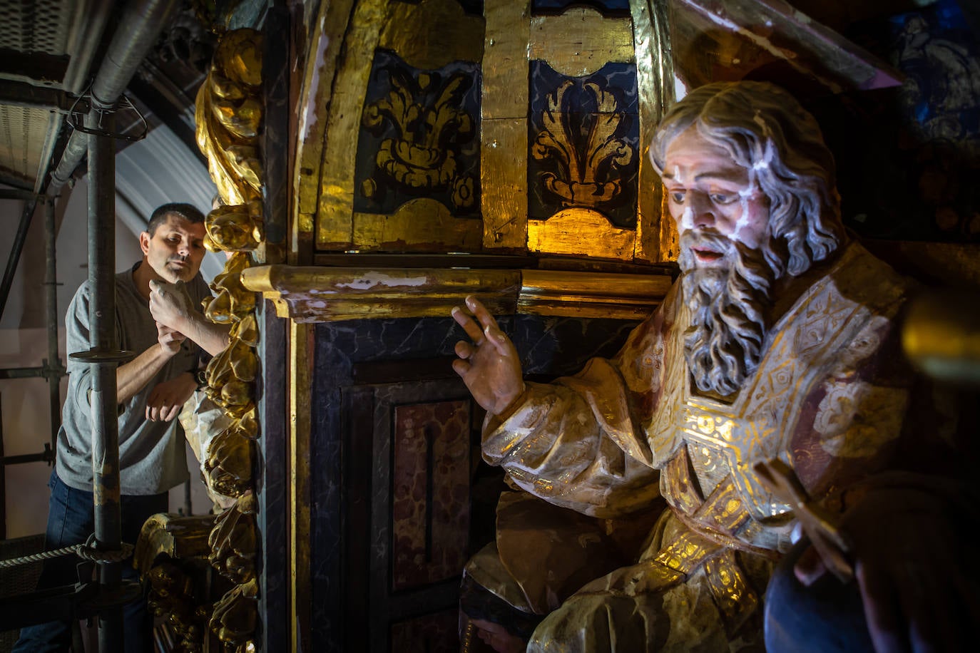 Alberto Estrada trabajando en la escultura de la Fe que se encuentra en el cuerpo superior;en primer plano, el Padre Eterno, también restaurado.