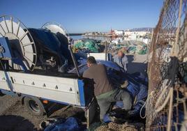 Pescadores arreglan sus redes en el puerto de Motril.