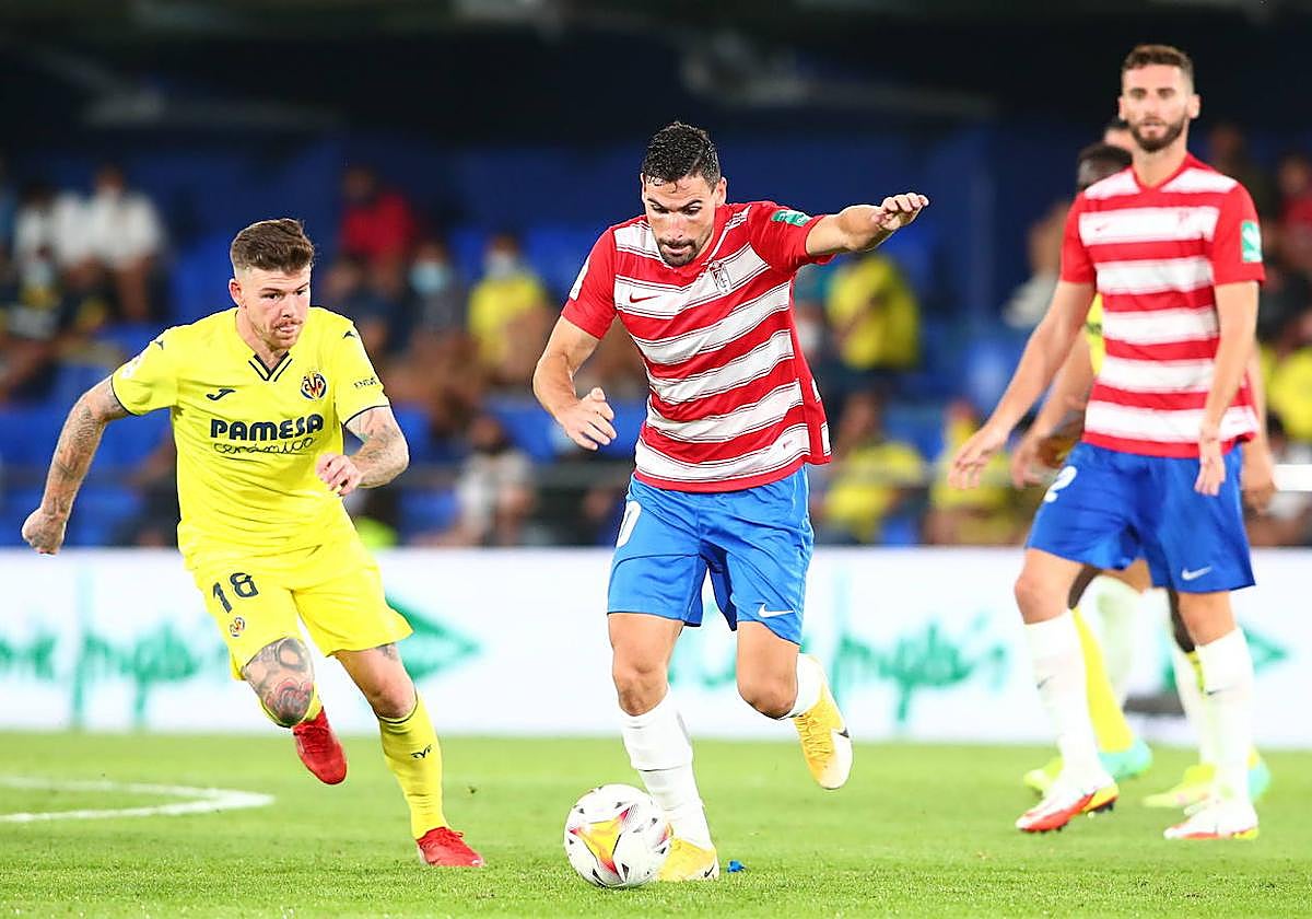 Antonio Puertas conduce un balón ante Alberto Moreno en la última visita del Granada al Estadio de la Cerámica para enfrentarse al primer equipo del Villarreal, en 2021.