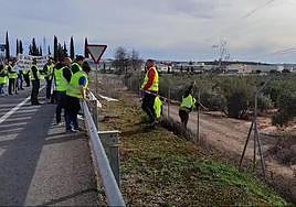 Agricultores lanzan ramas a un camino rural paralelo a la autovía en Guarromán