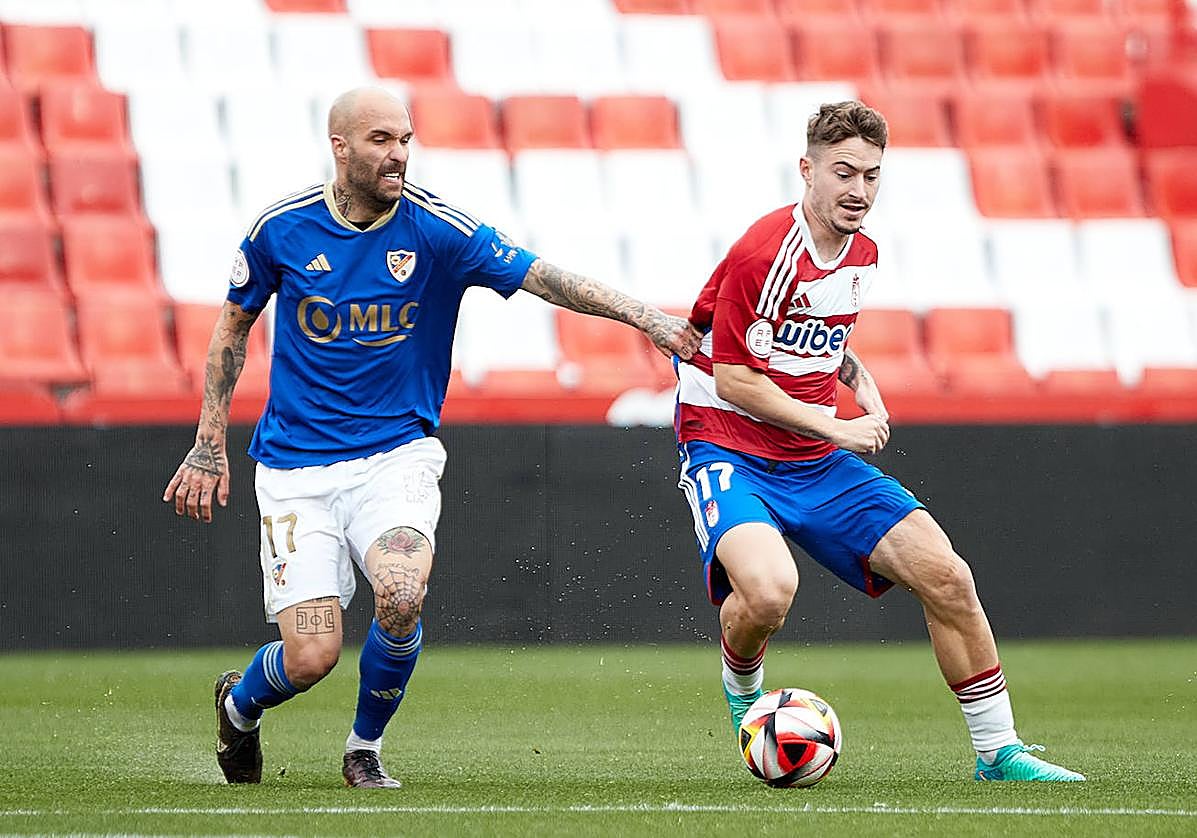 Ángel Martínez tratando de ganarle la posición a un atacante del filial del Granada en Los Cármenes.