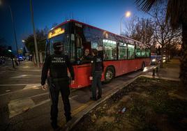 Dos agentes de la Policía Local conversan con un conductor del transporte público de Granada en el distrito Norte a la caída de la noche del lunes.