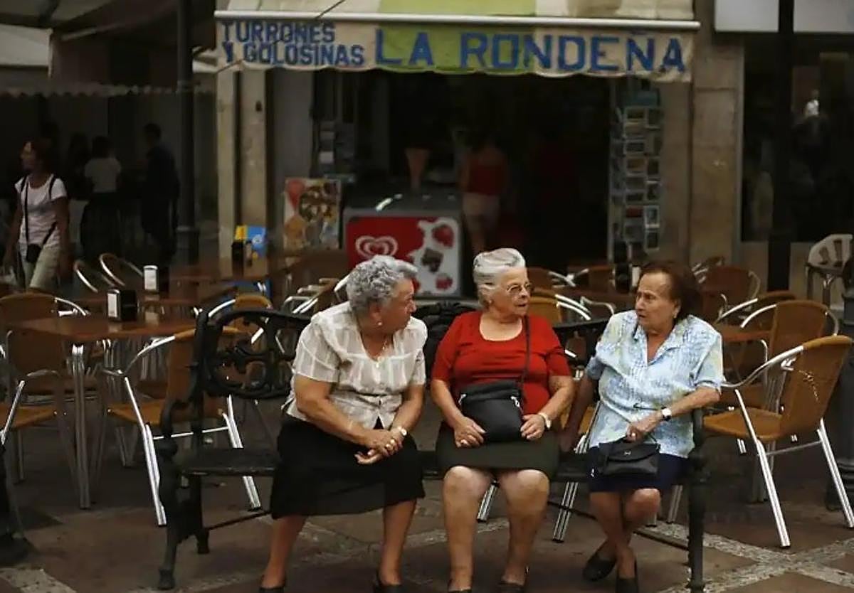 Tres mujeres conversan en una calle de Málaga.