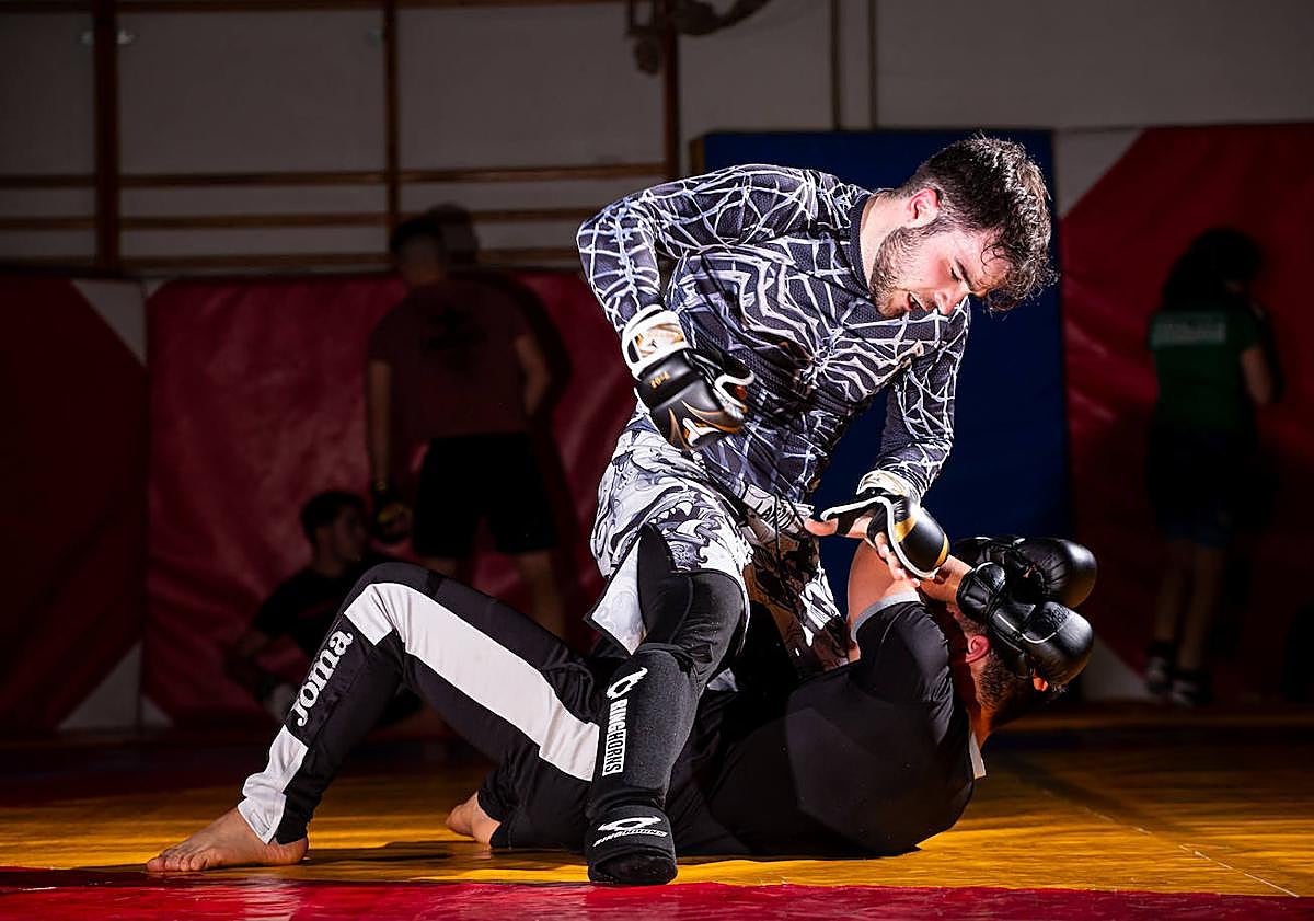 Imagen principal - Varios deportistas de la esceula de luchas de Maracena, durante un entrenamiento de MMA.