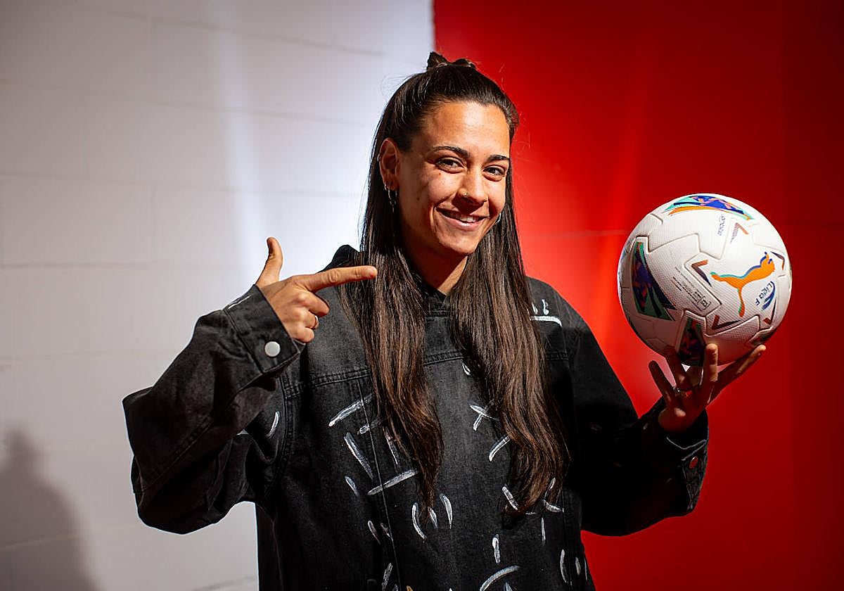 Isa Álvarez señala un balón de la Liga F para IDEAL, sonriente.