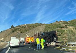 Los bomberos actúan para apagar el fuego en un camión que transportaba madera