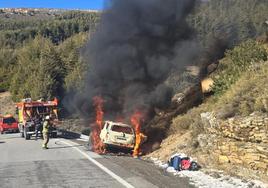 Un vehículo arde ante la presencia de los bomberos en la carretera que conecta con Sierra Nevada.