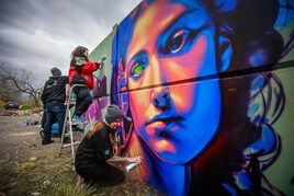 El colectivo, durante el proceso de pintado del muro.