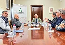 El delegado del Gobierno andaluz (centro) y representantes vecinales de los Puentes.