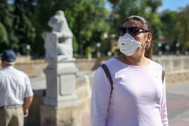 Personas caminan con una mascarilla por sus problemas de alergia en Granada.