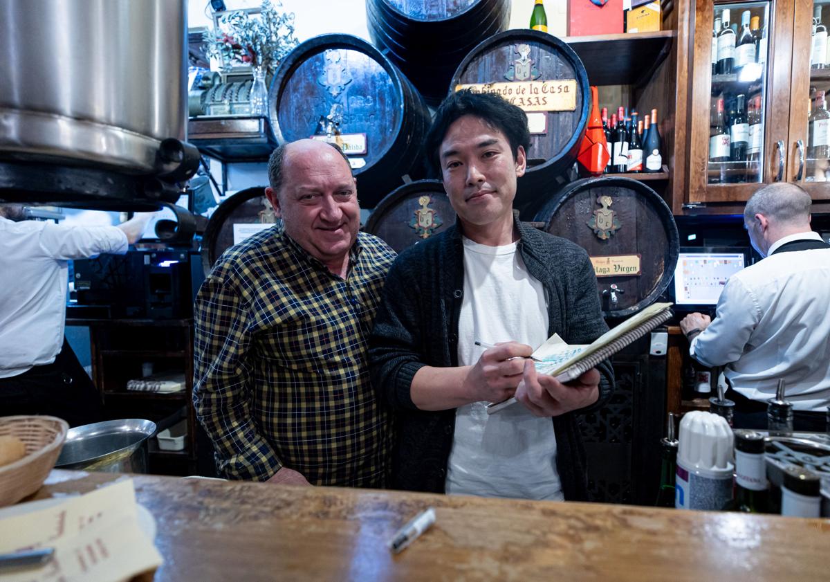 Imagen principal - Emoto, con Pepe Torres, de Bodegas Castañeda; y dibujando al periodista, que se llevó un buen recuerdo. 