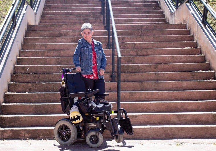 Ana Raya junto a su inseparable silla de ruedas y ante unas escaleras en un parque de Granada.