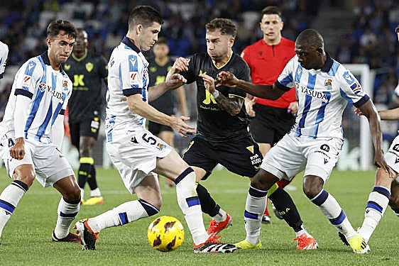 Adrián Embarba, entre Zubeldia y Traoré, se maneja con el balón para escapar.