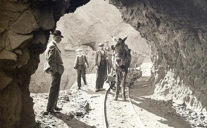 Imagen secundaria 1 - Arriba, monedas de 1 peseta de 1944; debajo, extracción de mineral de la vecina mina de Alquife en aquella época y acción que se vende en internet de la sociedad creada por Meermans en 1888.