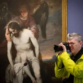 Fotógrafo delante de la obra prestada por el Prado, 'Cristo muerto sostenido por un ángel'.
