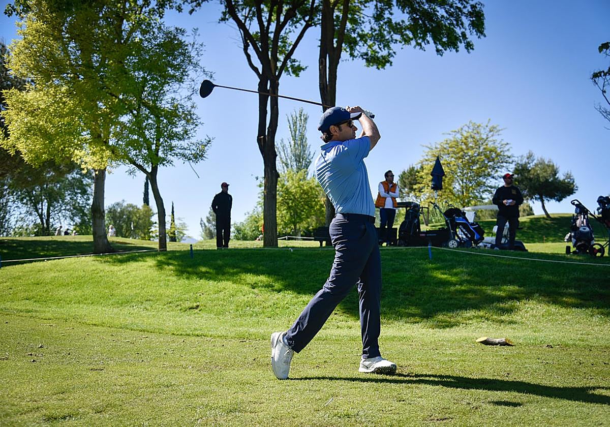 Un participante ejecuta un 'swing' con el palo 'driver' para aproximar la bola lo máximo posible a uno de los hoyos del recorrido.