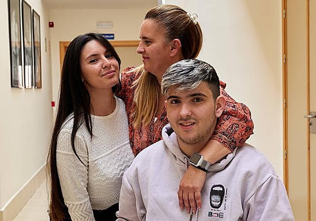 Rosa muestra su audífono, con Lucía y Eduardo, sus hijos.