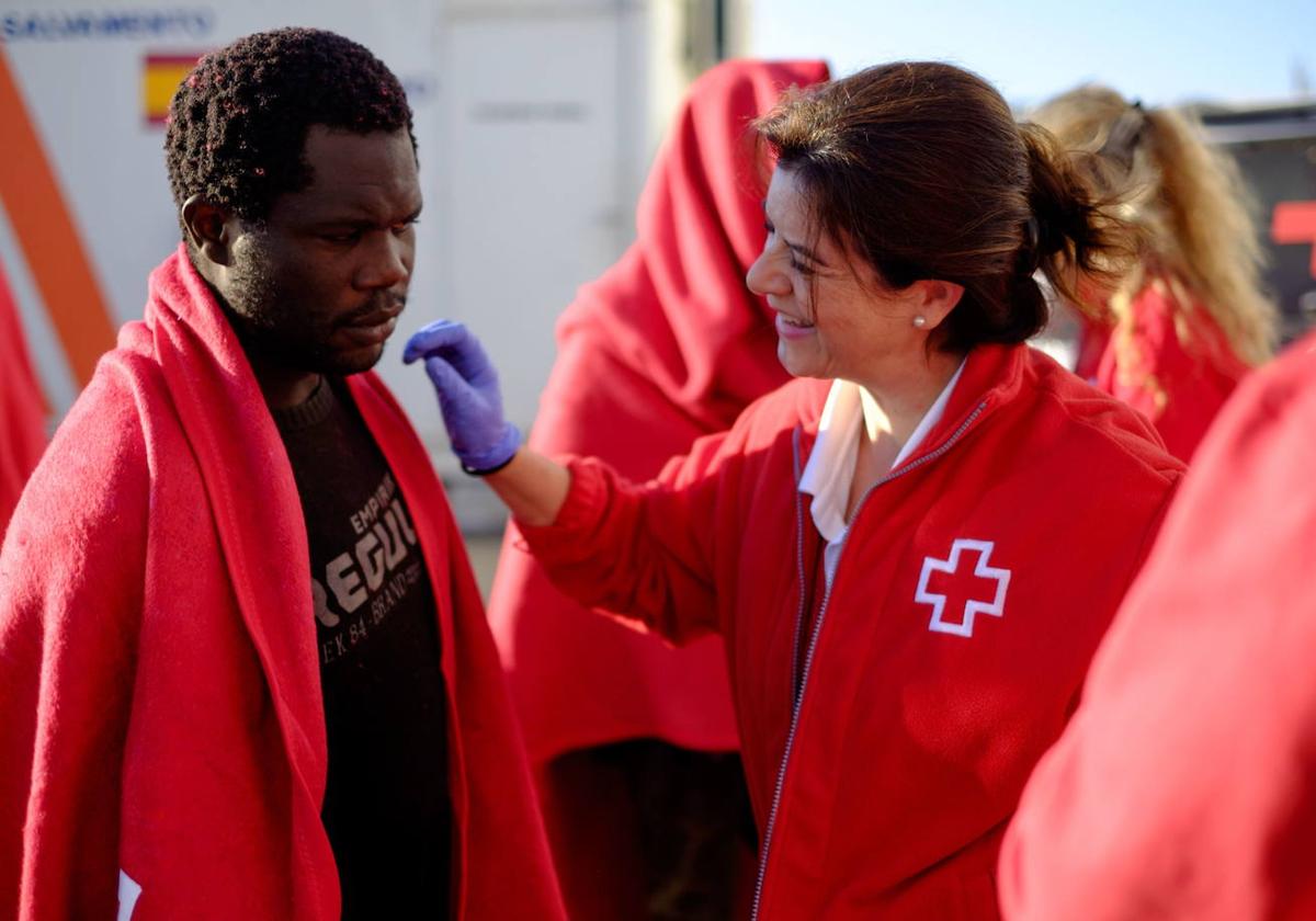 Personal de Cruz Roja atiende a un grupo de inmigrantes a su llegada al Puerto de Motril.