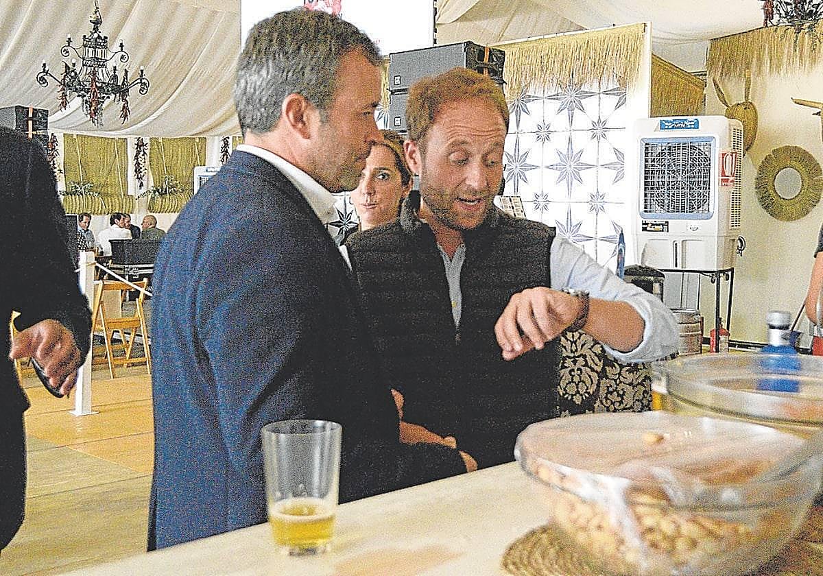 Julio Millán (PSOE) y Erik Domínguez (PP) comparten miran en reloj, en una Feria de San Lucas.