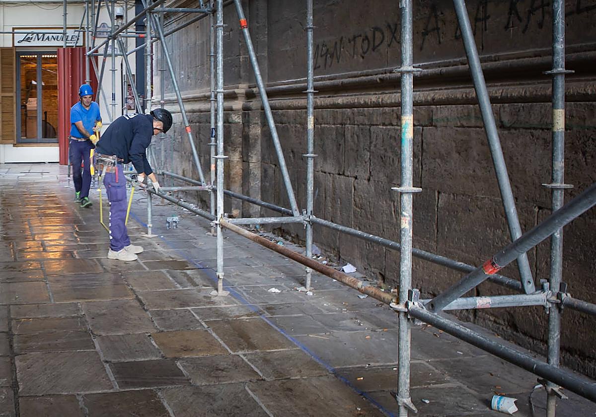 Operarios trabajando esta mañana en la preparación del andamio.