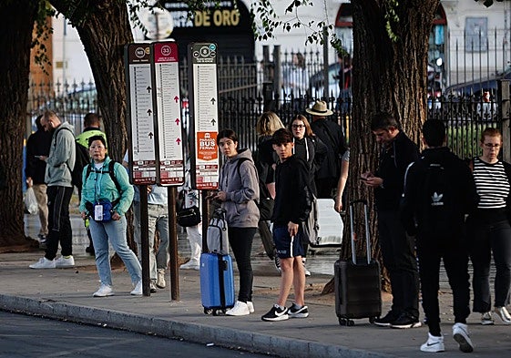 Usuarios esperan al autobús en la parada de Triunfo este viernes