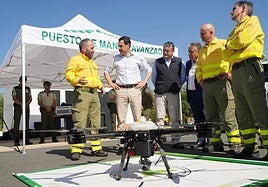 Juanma Moreno y el consejero Antonio Sanz observan junto a responsables del Infoca uno de los drones de vigilancia.