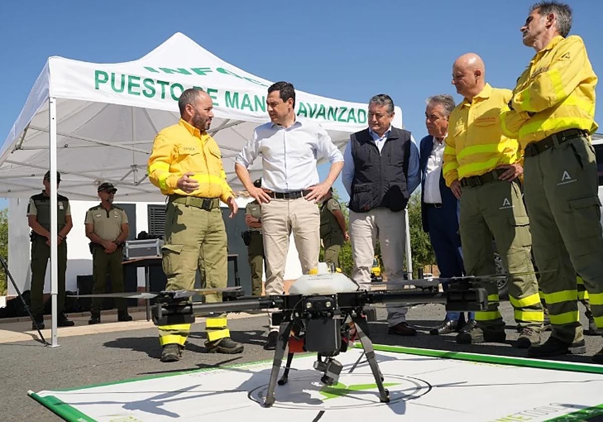 Juanma Moreno y el consejero Antonio Sanz observan junto a responsables del Infoca uno de los drones de vigilancia.