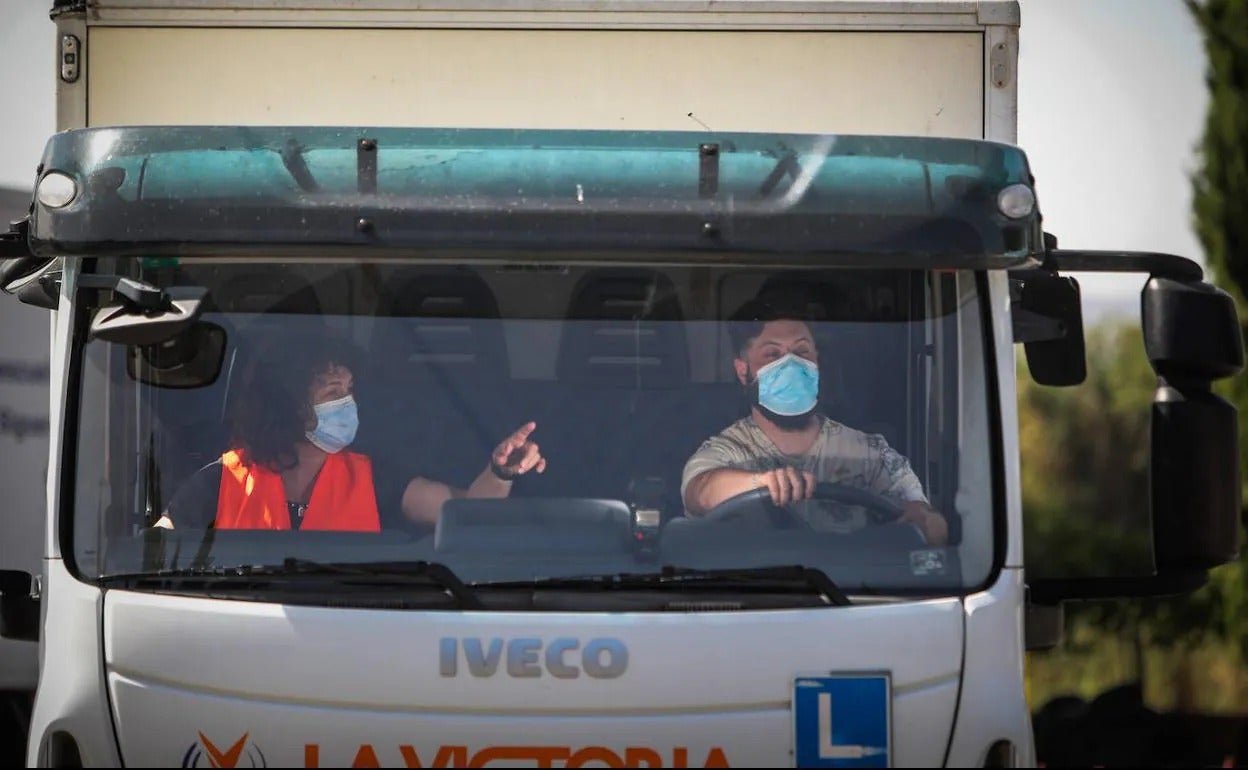 Una profesora explica a un alumno que hace prácticas con un camión de una autoescuela de Granada.
