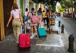 Turistas con maletas por el Realejo.