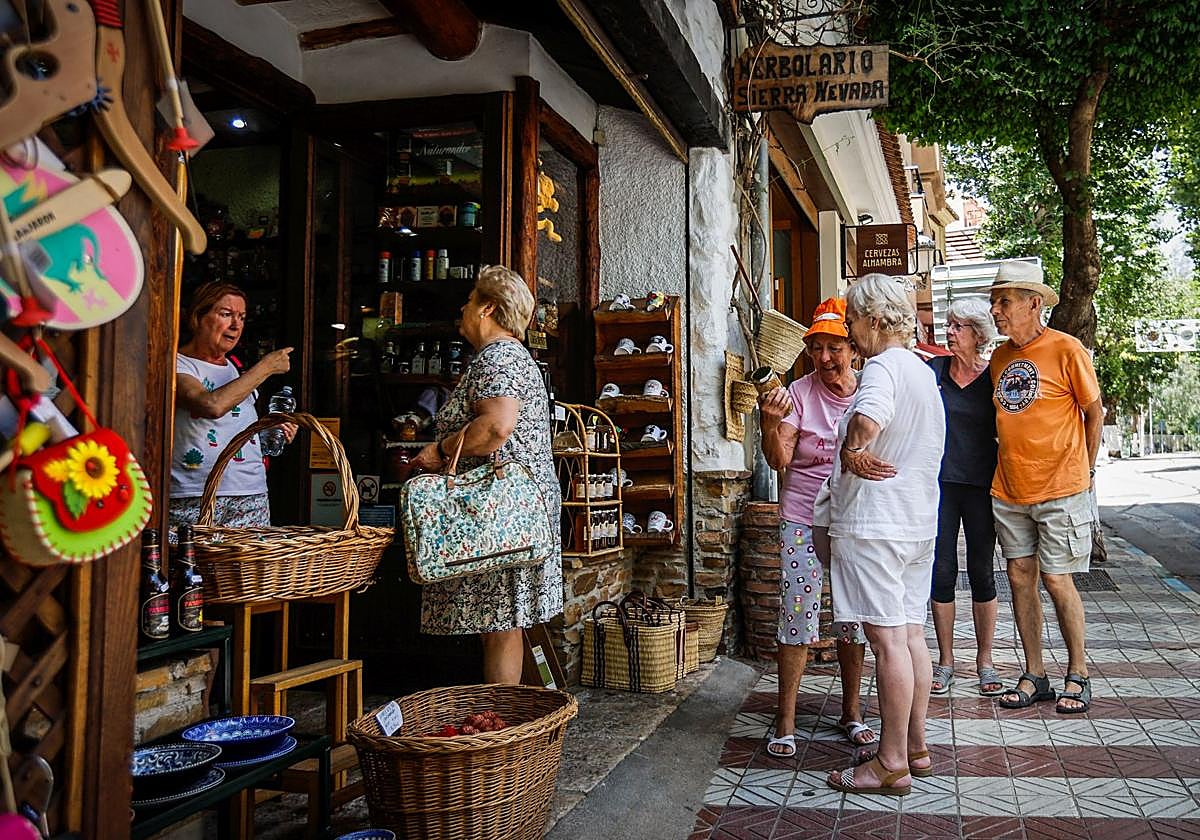 Un grupo de turistas hace cola frente a una tienda de regalos y productos típicos de Lanjarón el pasado viernes.
