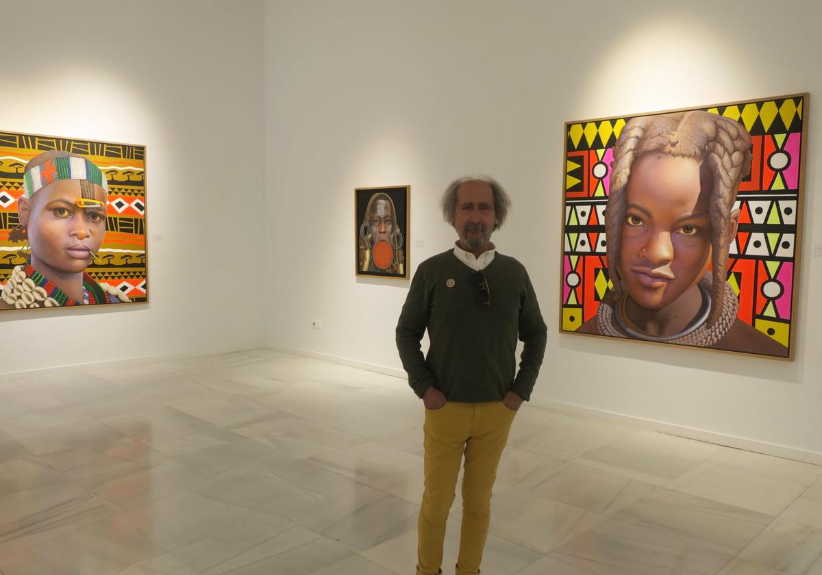 Román, entre los retratos de tres mujeres.