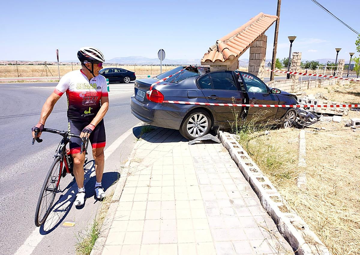 Imagen secundaria 1 - Varios vecinos de Ogíjares contemplan el coche siniestrado.