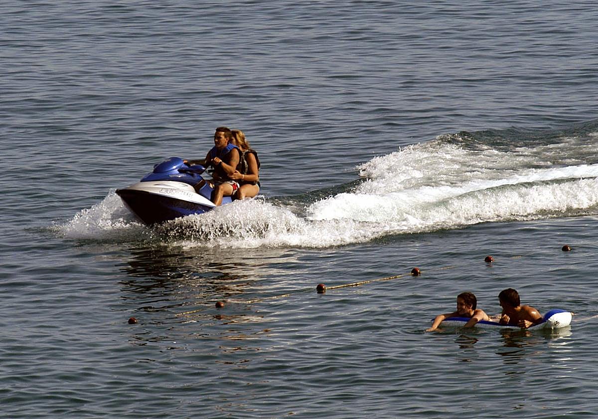 Los bañistas en una moto de agua detrás de la línea de zona de baño.