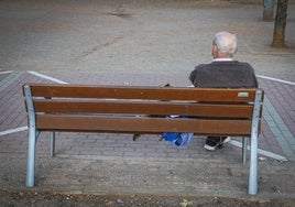 Un hombre mayor, sentado en un banco.