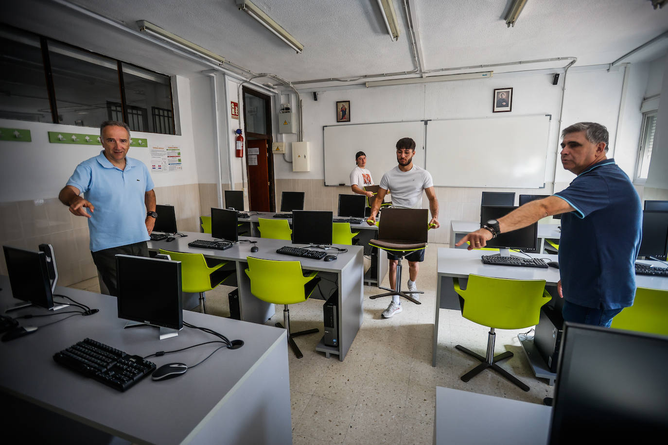 El director del centro de FP de la Fundación don Bosco, José Manuel Olivencia (izquierda) y el jefe de estudios de FP Víctor Márquez ordenando el material de CaixaBank en su aula de Informática.