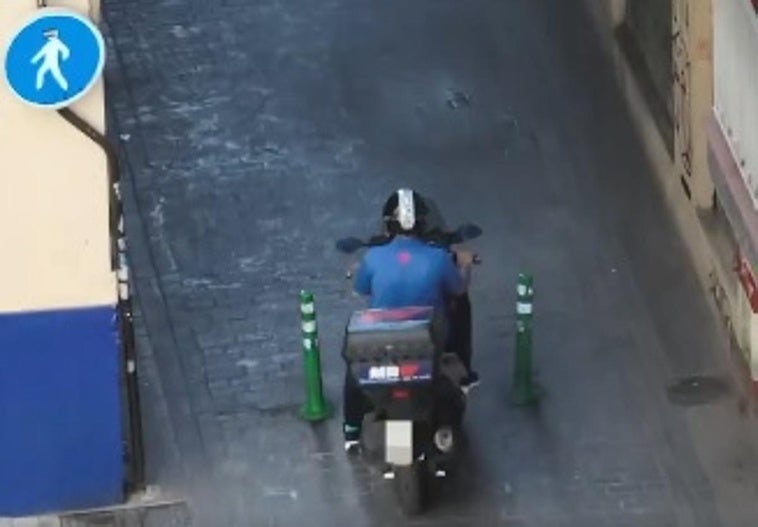 Un motorista pasa por esta calle en la que está prohibido circular con vehículos a motor en Granada