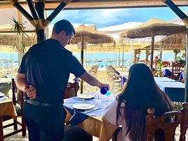 Camarero del Chiringuito Casa Emilio sirviendo una copa de 'vino azul'.