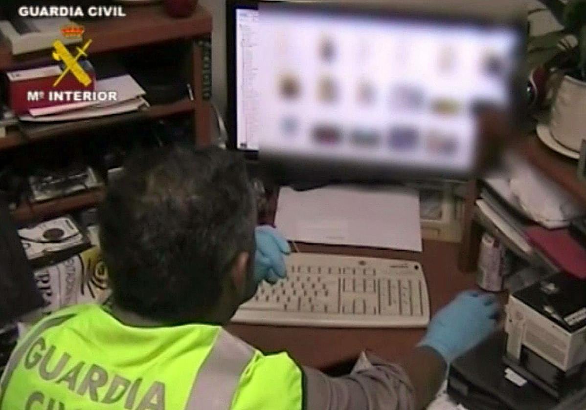 Un agente de la Guardia Civil revisa el contenido de un ordenador en una imagen de archivo.
