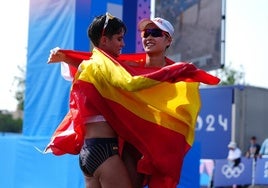 María Pérez y la campeona Yang se abrazan con las banderas de sus países.