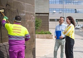 Antonio Urdiales y María del Mar Vázquez observan el trabajo de un operario de limpieza de graffitis.