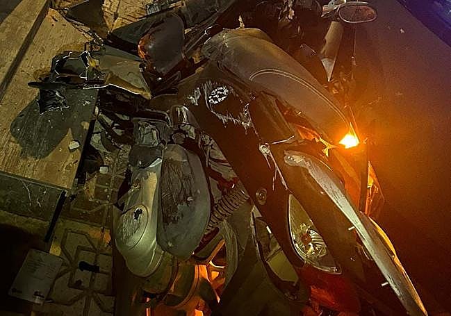 La moto que el coche se llevó por delante, destrozada.