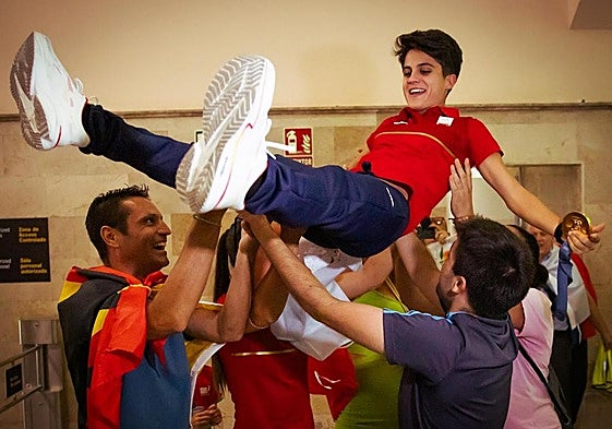 Amigos y familiares de María Pérez mantean a la marchadora a su llegada al aeropuerto de Granada.