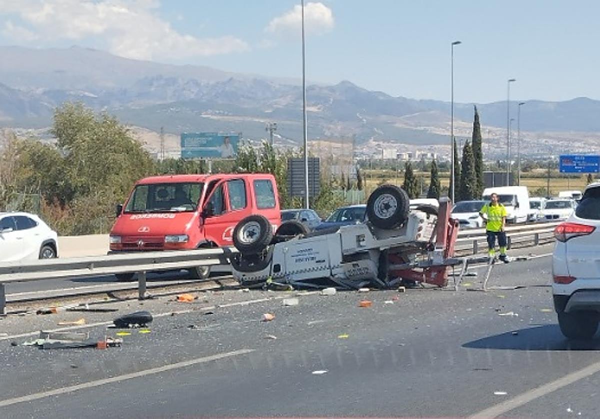 El coche grúa volcado en la Circunvalación de Granada.