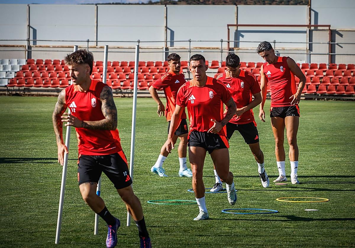 Los futbolistas del Granada esprintan entre picas durante el calentamiento del entrenamiento previo al partido contra el Albacete.