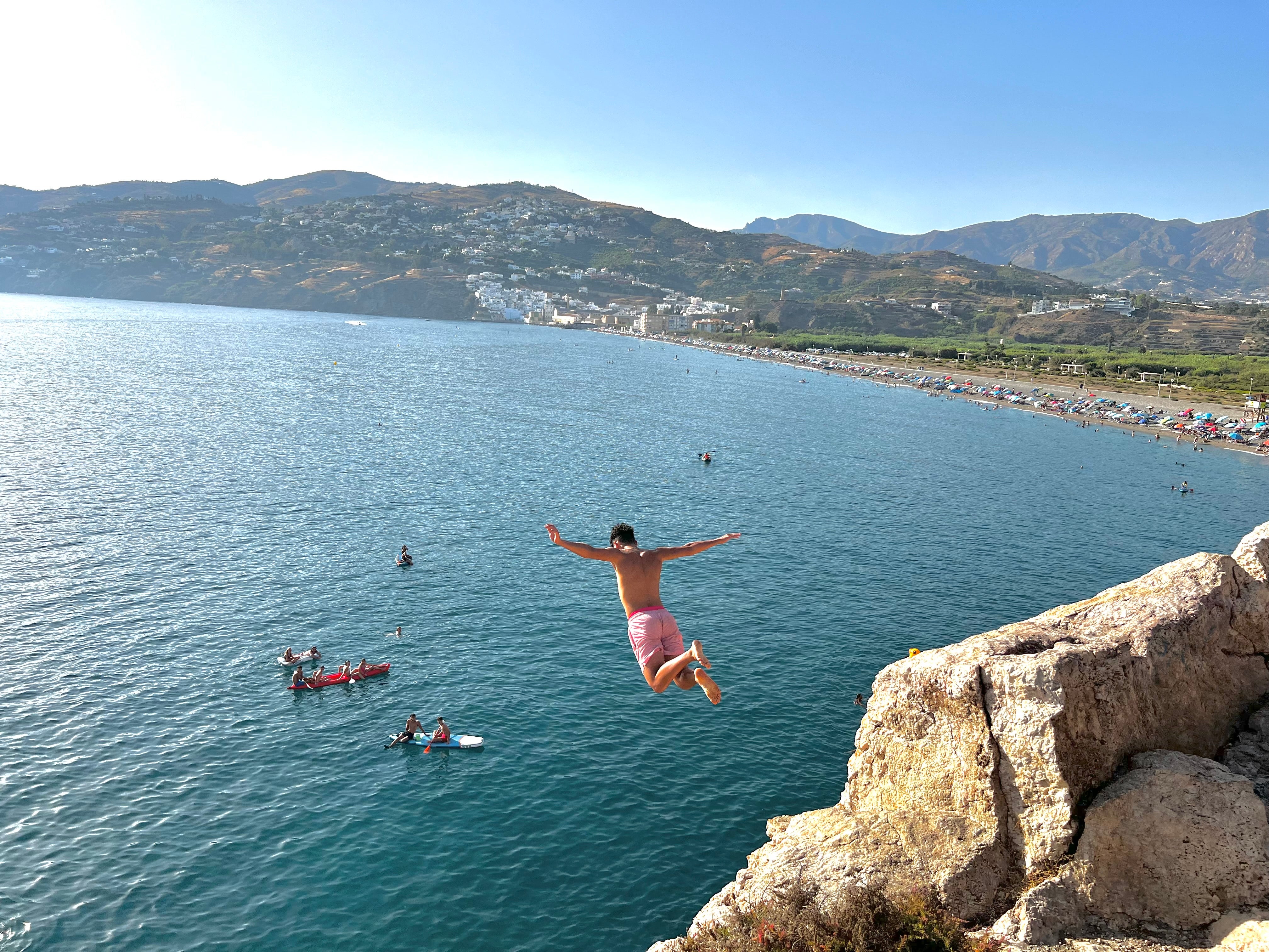 Un joven tirándose al agua por el peñón de Salobreña.