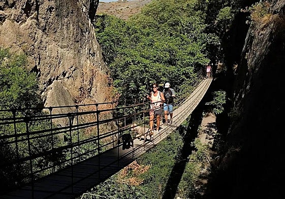 Visitantes cruzando el puente colgante de los Cahorros de Monachil.
